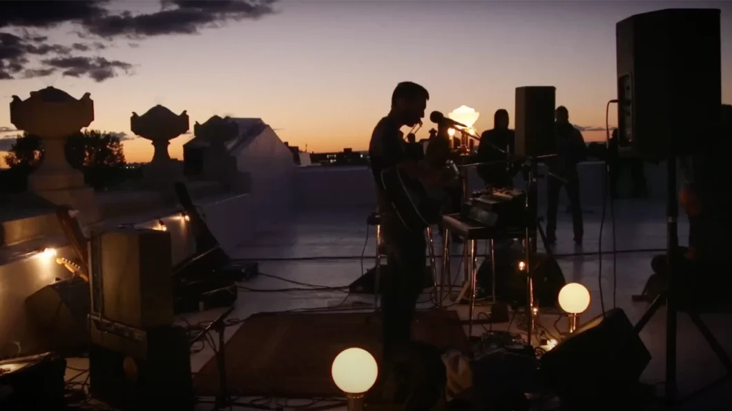 Leif Vollebekk performs on a waterfront at dusk - Twin Solitudes