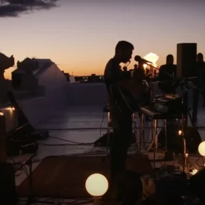 Leif Vollebekk performs on a waterfront at dusk - Twin Solitudes